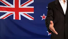 Open hand and New Zealand flag in the background