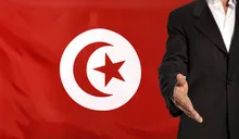 Open hand and Tunesia flag in the background