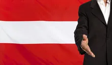 Open hand and Austria flag in the background