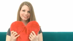 Woman On Sofa Cuddling Heart Pillow