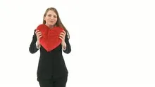 Woman cuddling with a heart pillow