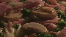 Time lapse pan shot pizza with ham and mushrooms