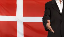 Open hand and Denmark flag in the background