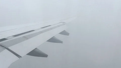Airplane Wings Flying Through Clouds