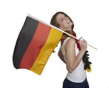 Attractive Woman Shows German Flag And Smiles In Front Of White Background