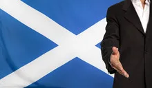 Open hand and Scotland flag in the background