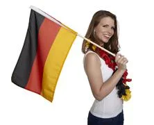 Attractive Woman Shows German Flag And Smiles In Front Of White Background