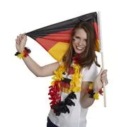 Attractive Woman Shows German Flag And Smiles In Front Of White Background