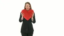 Woman throws a heart pillow into the camera