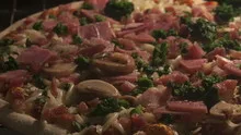 Time lapse pan shot pizza with ham and mushrooms